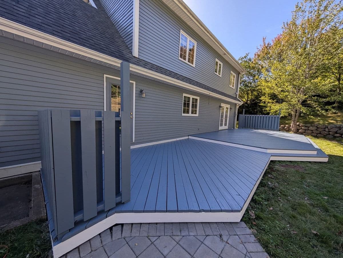 A new wooden deck in a backyard painted blue